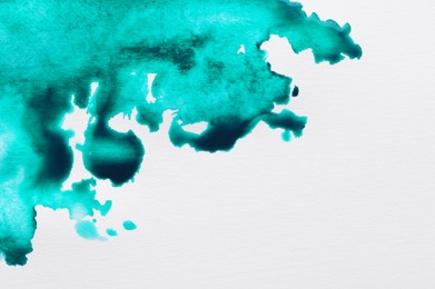 Photo of Blot of turquoise ink on white background, top view. Space for text