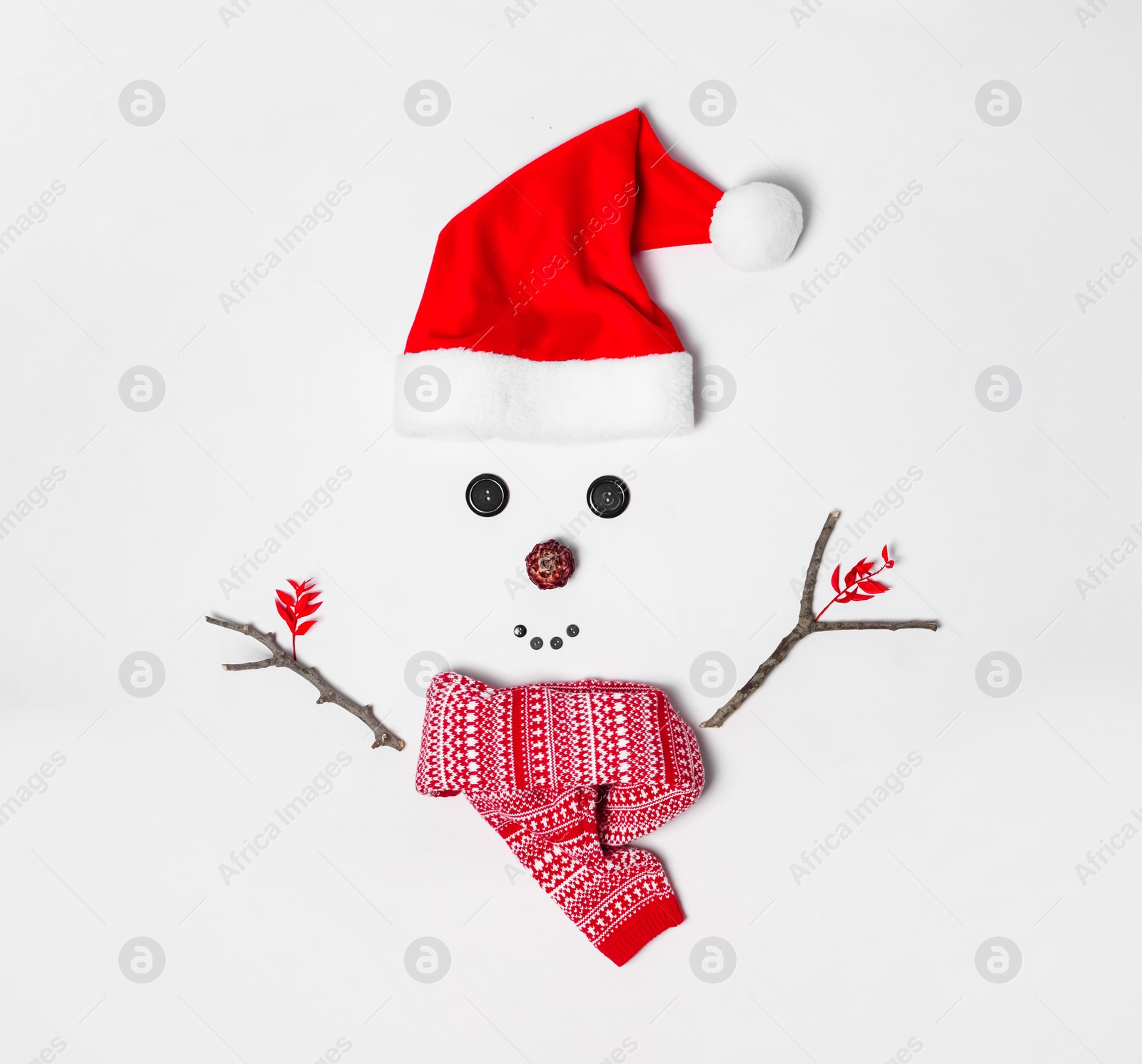 Photo of Creative snowman shape made of Santa hat and different items on white background, flat lay