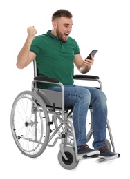 Photo of Happy young man in wheelchair with mobile phone isolated on white