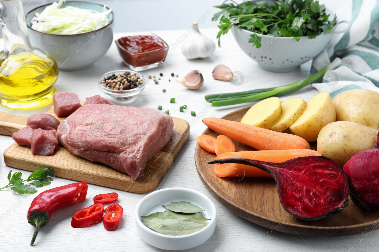 Photo of Fresh ingredients for borscht on white wooden table