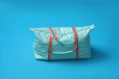 Photo of Gym bag on blue background. Sport equipment