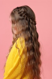 Cute little girl with braided hair on pink background