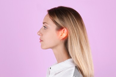 Young woman with hearing problem on pink background