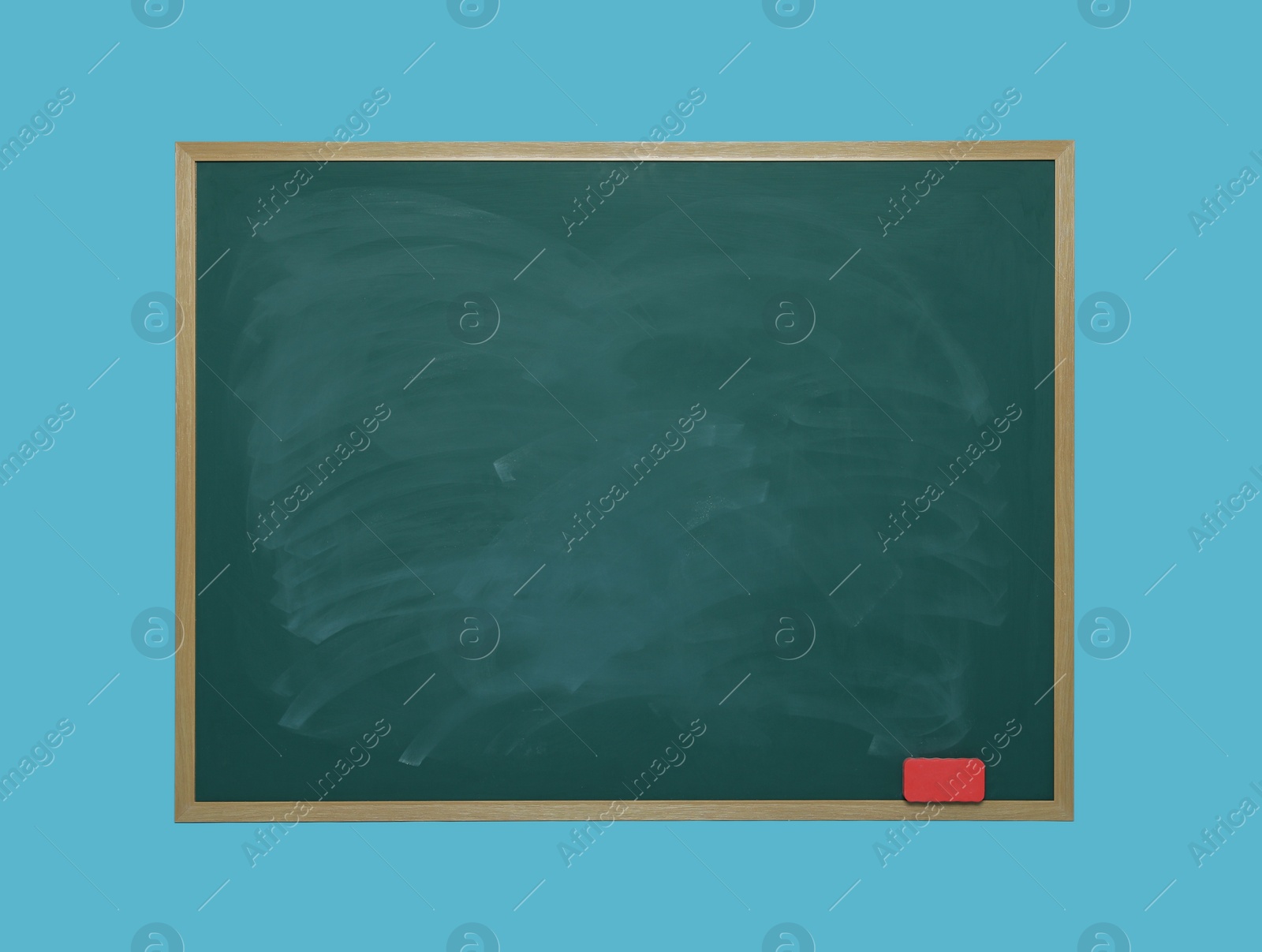 Photo of Dirty green chalkboard with duster on light blue background