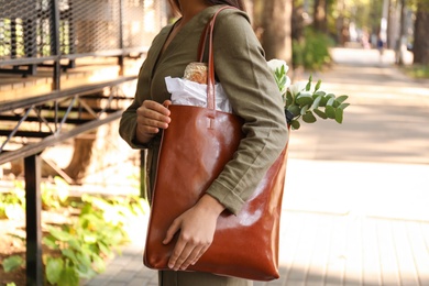 Photo of Woman with leather shopper bag on city street, closeup