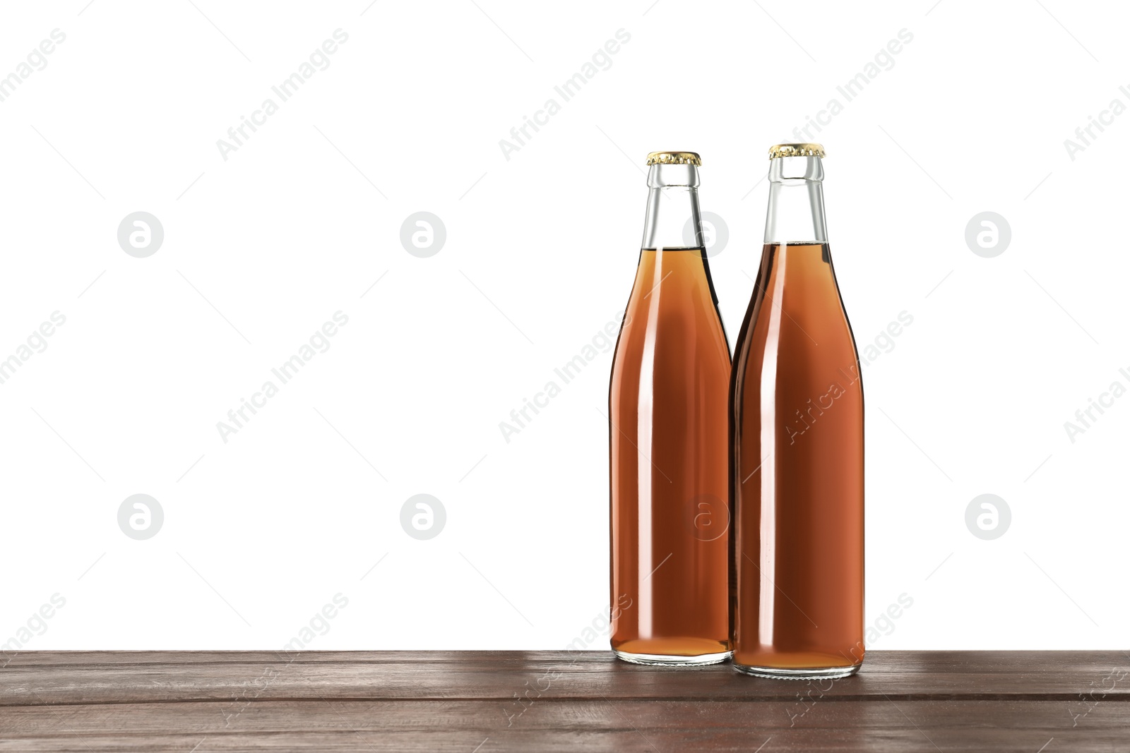 Photo of Bottles of delicious kvass on wooden table against white background