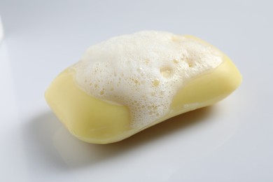 Photo of Soap and fluffy foam on white background