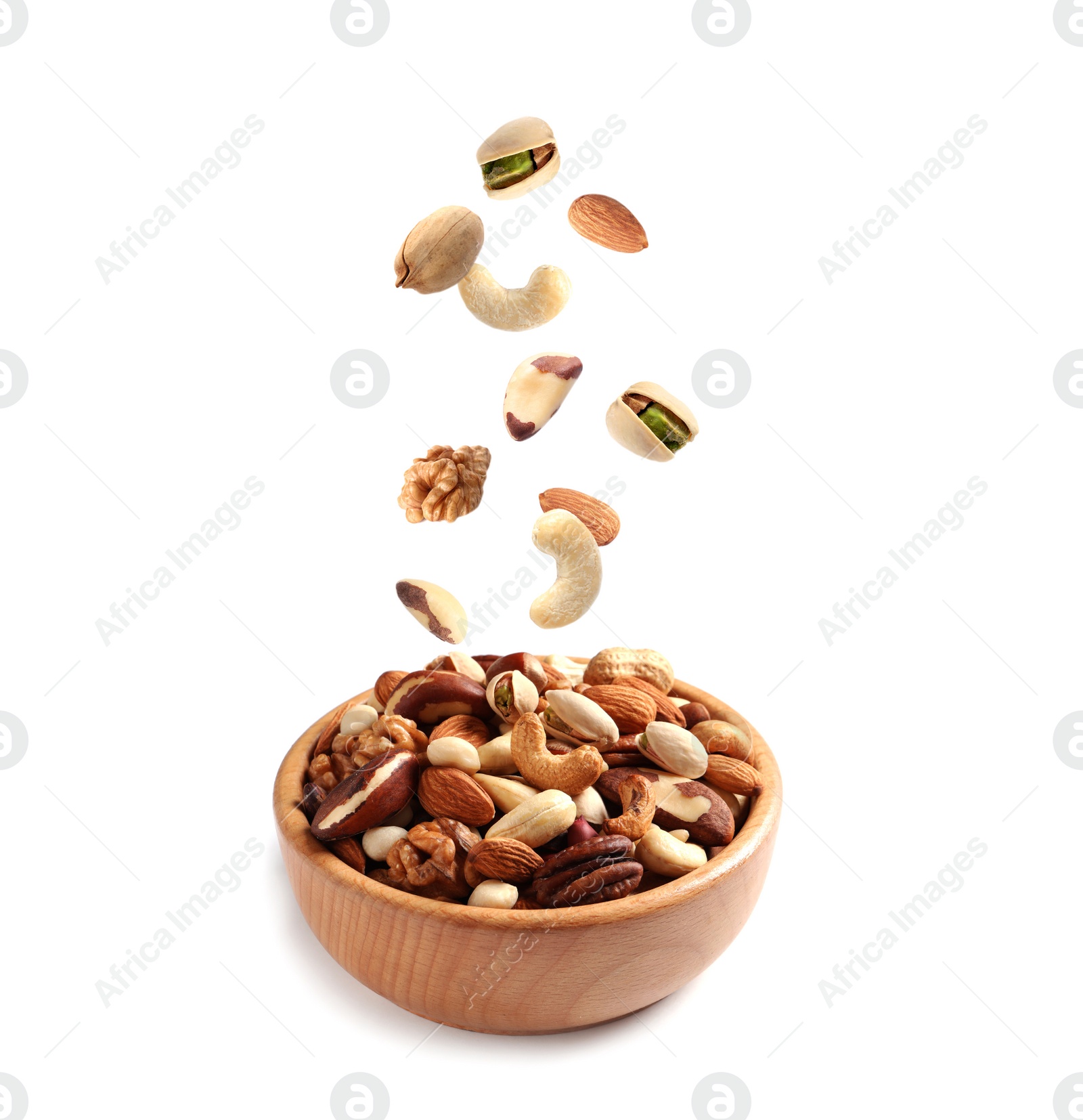 Image of Different nuts falling into bowl on white background 