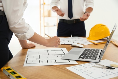 Photo of People working with construction drawings at table, closeup