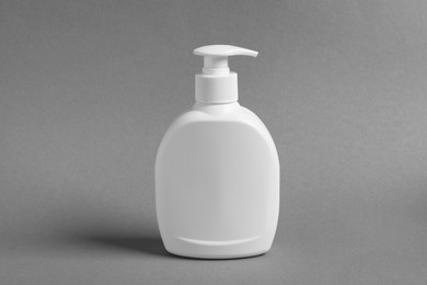 Photo of Bottle with cosmetic product on grey background