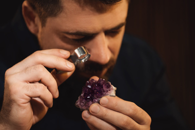 Photo of Jeweler working with gemstone on blurred background, closeup