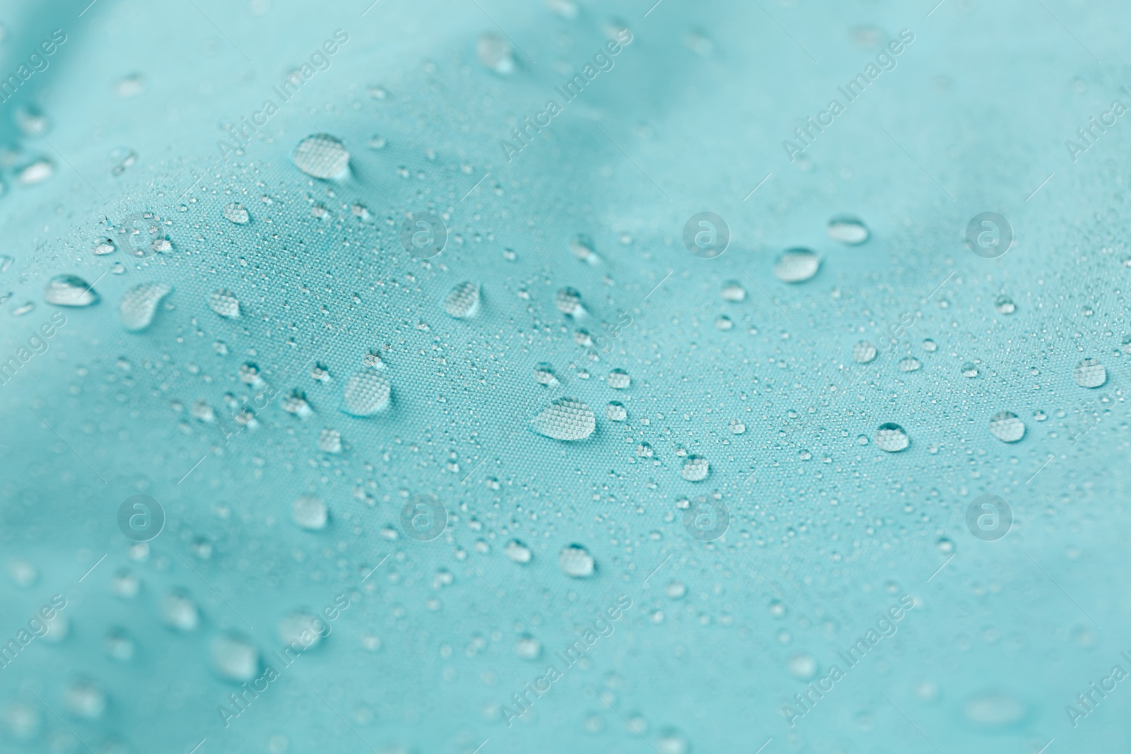 Photo of Turquoise waterproof fabric with water drops as background, closeup