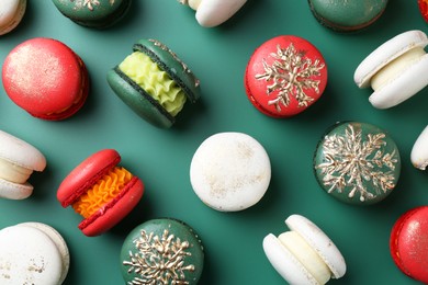 Beautifully decorated Christmas macarons on green background, flat lay