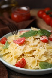 Tasty pasta with tomato, cheese and basil on table, closeup