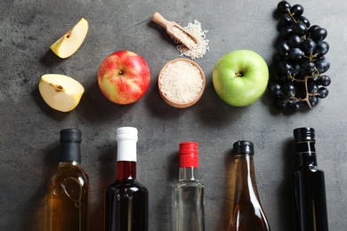 Photo of Flat lay composition with different kinds of vinegar and ingredients on grey background