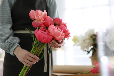 Photo of Florist with beautiful peony bouquet indoors, closeup. Space for text