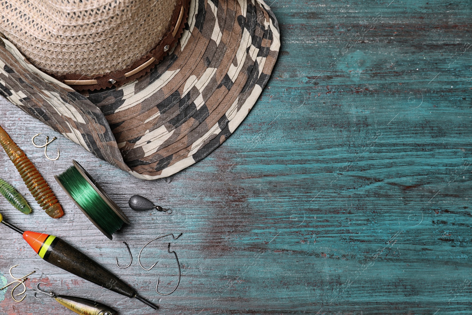 Photo of Flat lay composition with fishing equipment and space for text on wooden background