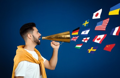 Image of Portrait of interpreter with megaphone and flags of different countries on blue background