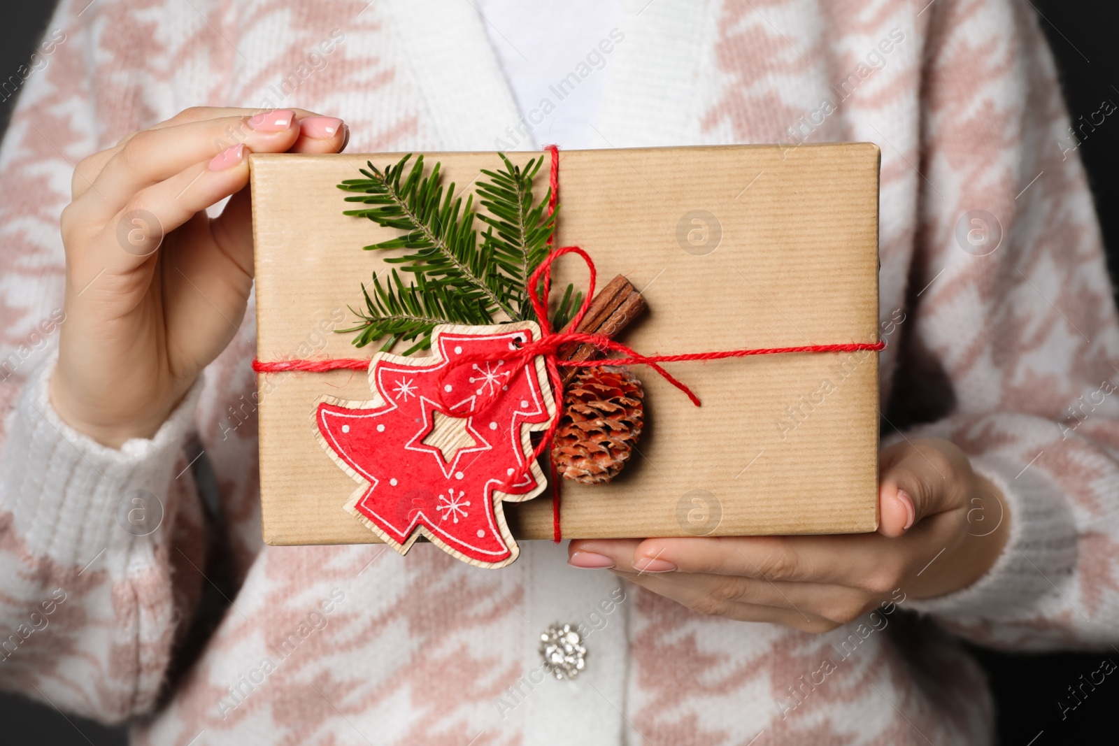 Photo of Christmas present. Woman holding beautifully wrapped gift box, closeup