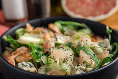 Photo of Delicious pomelo salad with shrimps, cheese and chia seeds in bowl, closeup