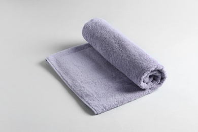 Photo of Fresh fluffy rolled towel on grey background