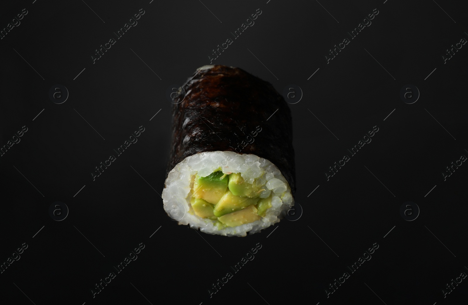 Photo of Sushi roll with avocado on black background