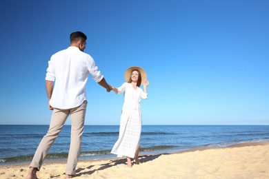 Photo of Lovely couple walking on beach. Space for text