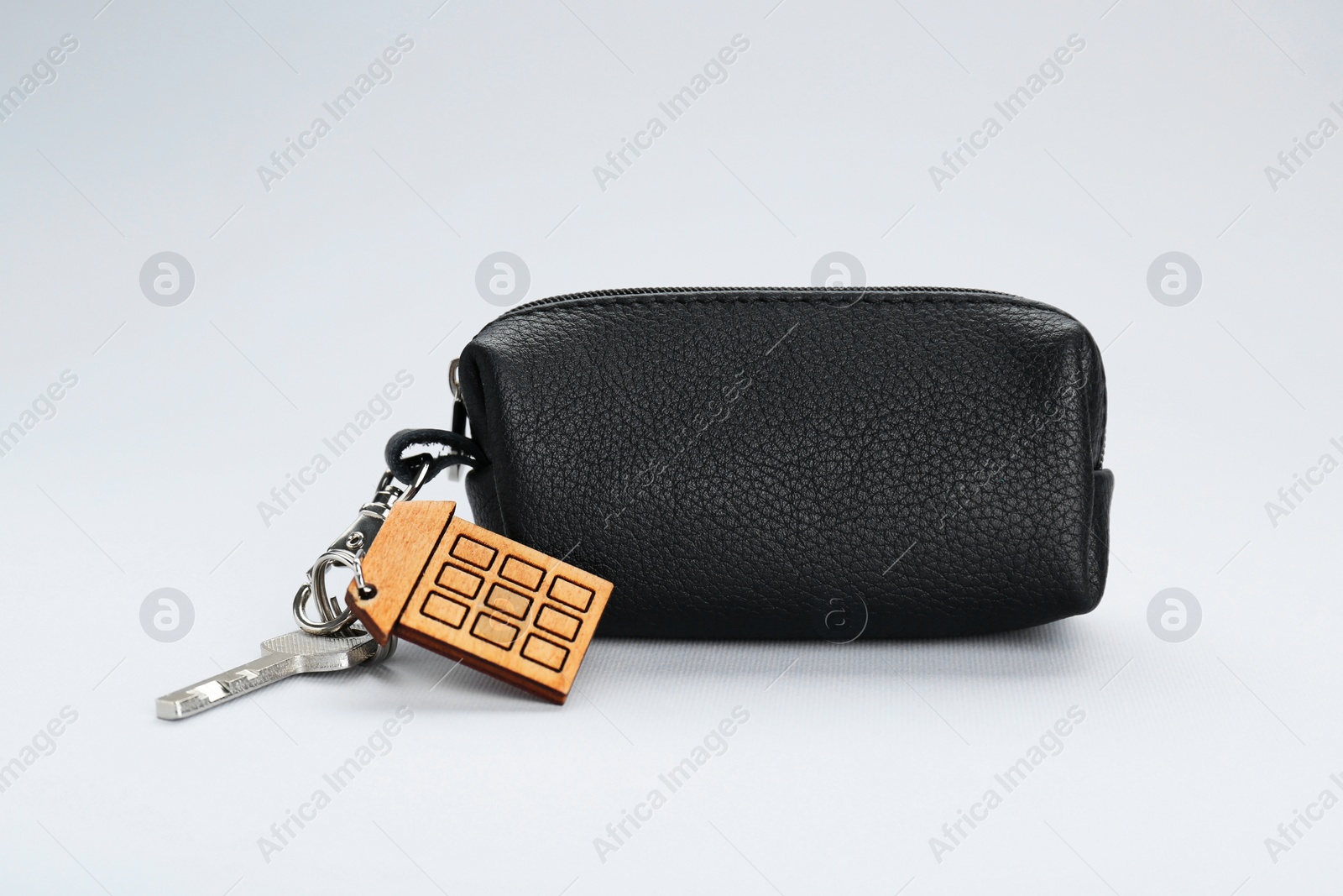 Photo of Leather case with keys on light grey background