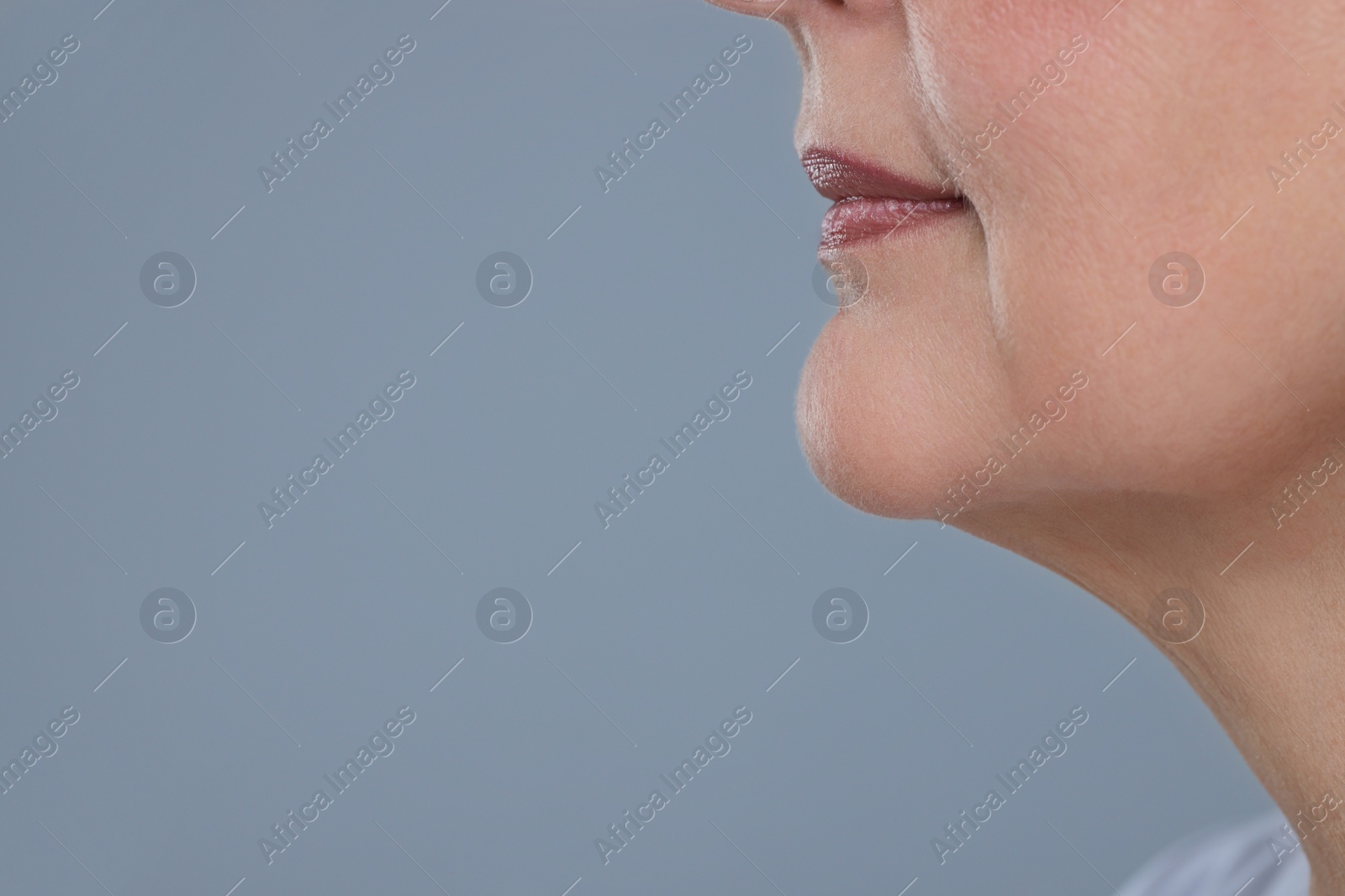 Photo of Senior woman with aging skin on grey background, closeup and space for text. Rejuvenation treatment