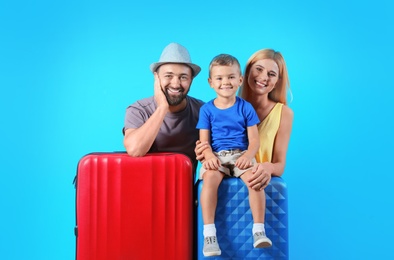 Photo of Happy family with suitcases on color background. Vacation travel