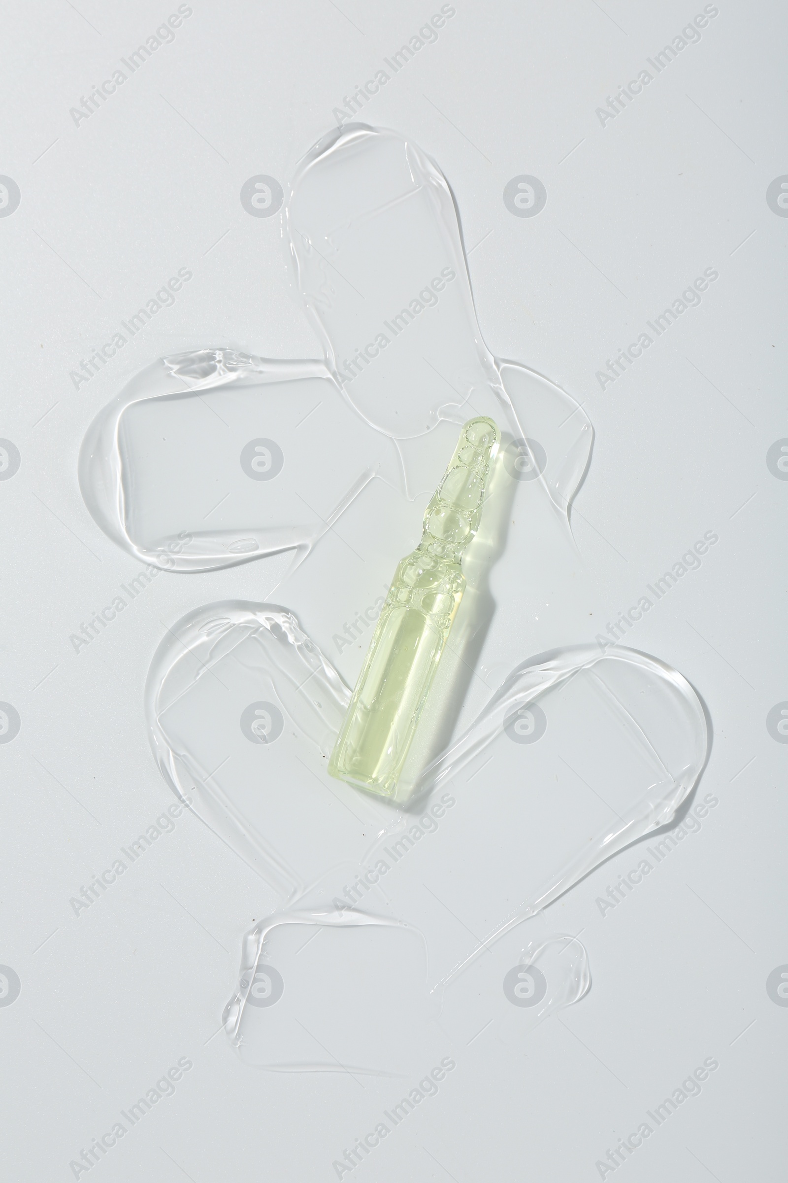 Photo of Skincare ampoule on white surface with gel, top view