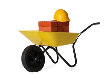 Photo of Red bricks and hard hat in wheelbarrow on white background