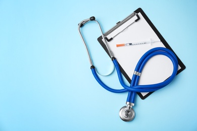 Photo of Stethoscope, clipboard and syringe on color background, top view. Medical equipment