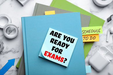 Image of Reminder note with phrase ARE YOU READY FOR EXAMS and stationery on table, flat lay