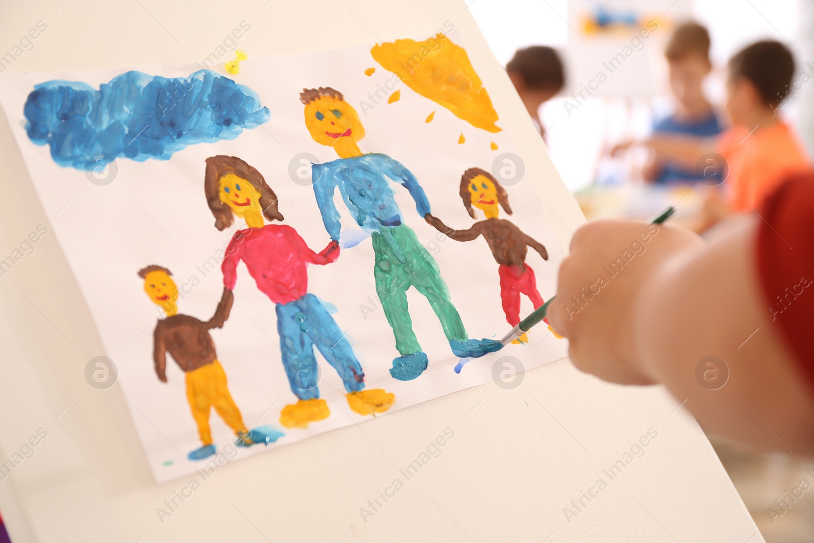 Photo of Little child painting family indoors, closeup view