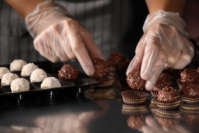 Woman packing delicious candies at production line, closeup