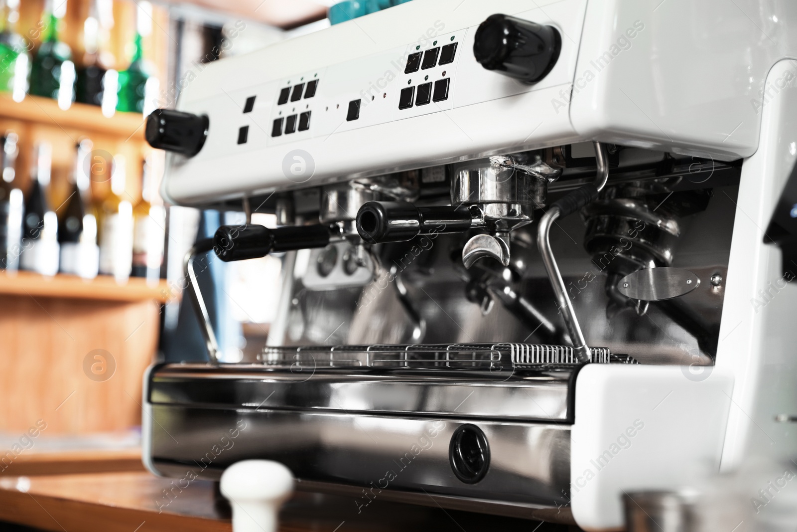 Photo of Modern coffee machine on bar counter in cafe