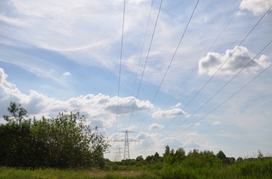 Photo of Modern high voltage towers in field on sunny day