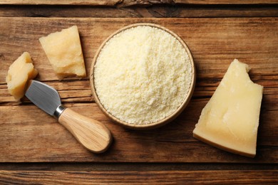 Photo of Flat lay composition with grated parmesan cheese and knife on wooden table