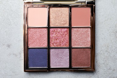 Photo of Beautiful eye shadow palette on grey table, top view