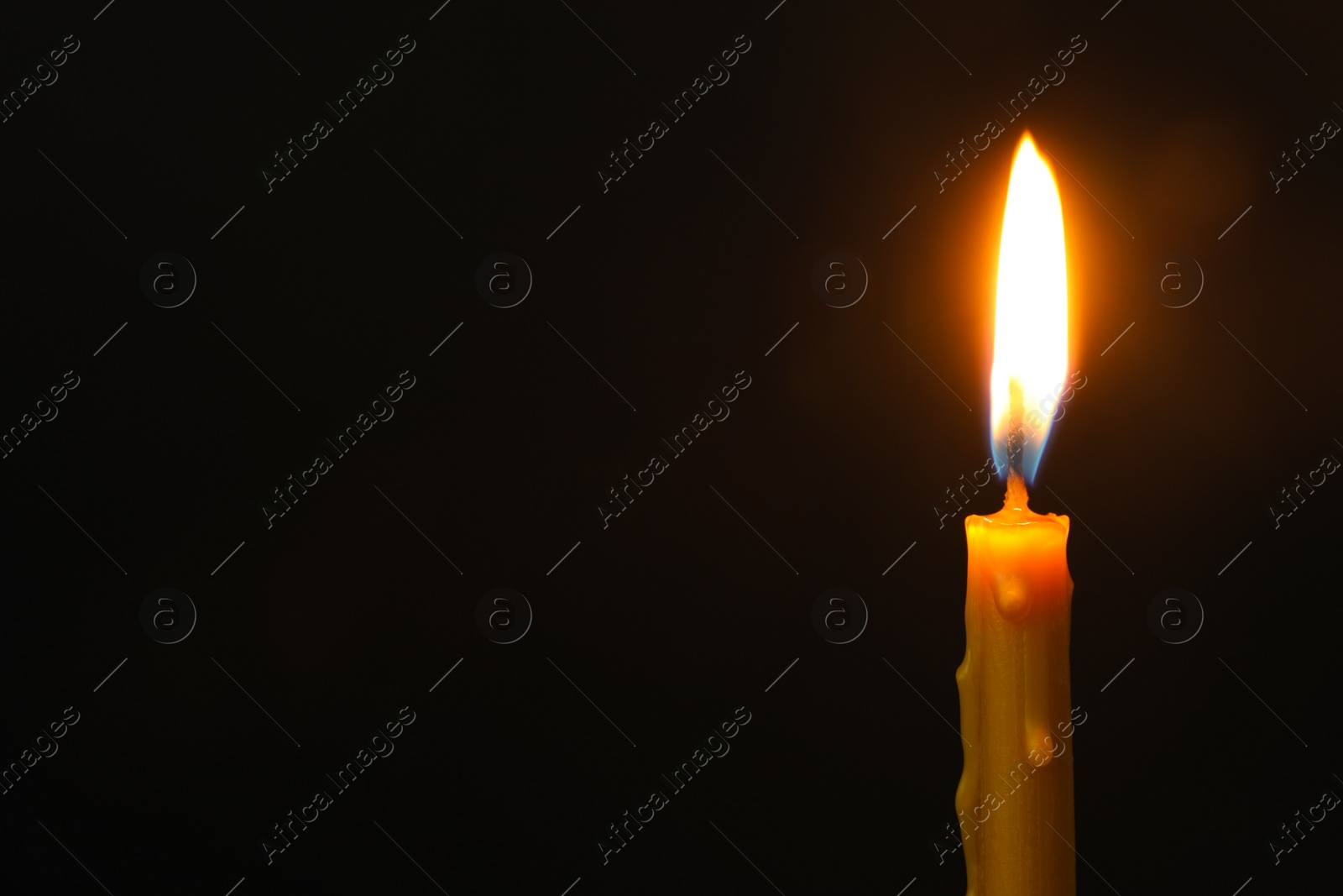 Photo of Burning candle on dark background, space for text. Symbol of sorrow