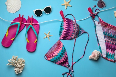 Flat lay composition with swimsuit and beach accessories on color background