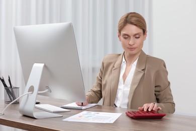 Professional accountant working at wooden desk in office