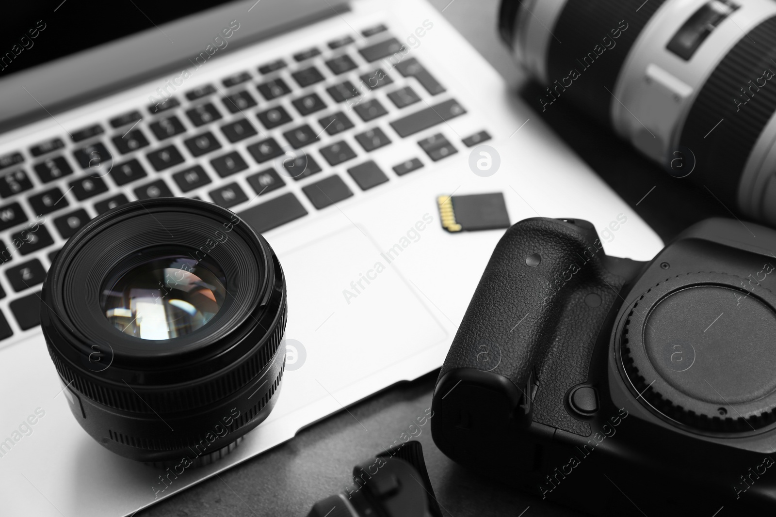 Photo of Professional photographer equipment and laptop on table