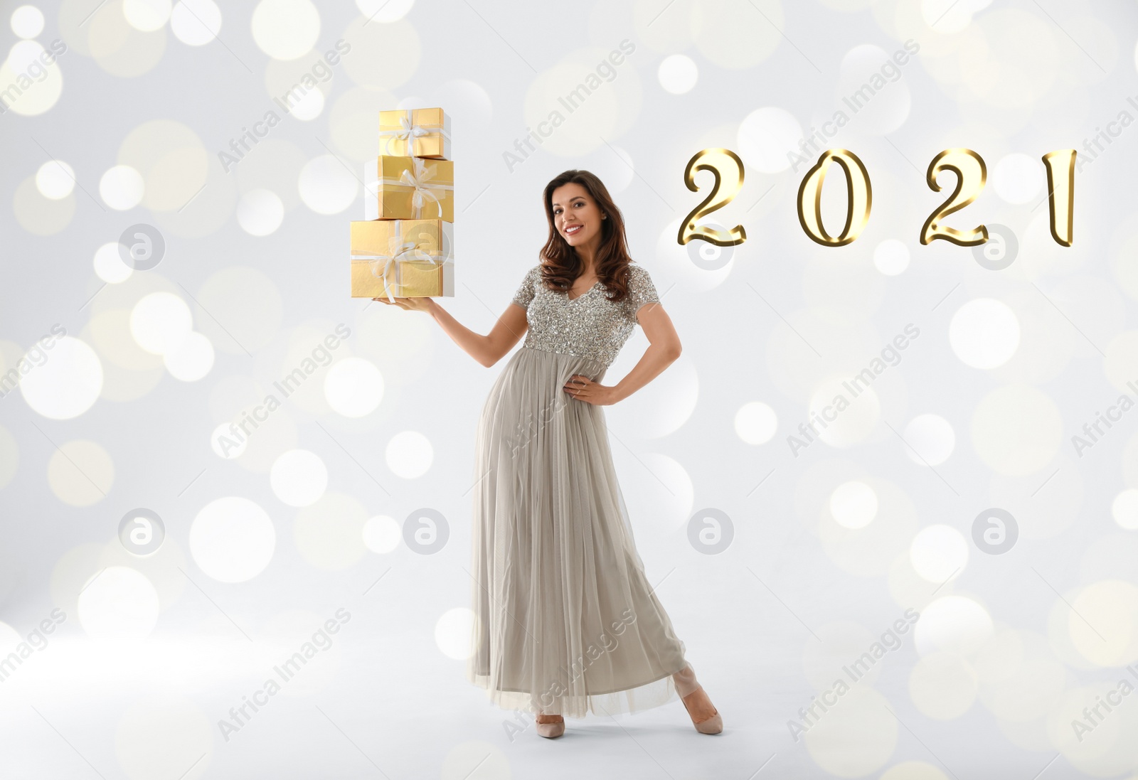 Image of Beautiful woman with Christmas gifts on white background. Bokeh effect