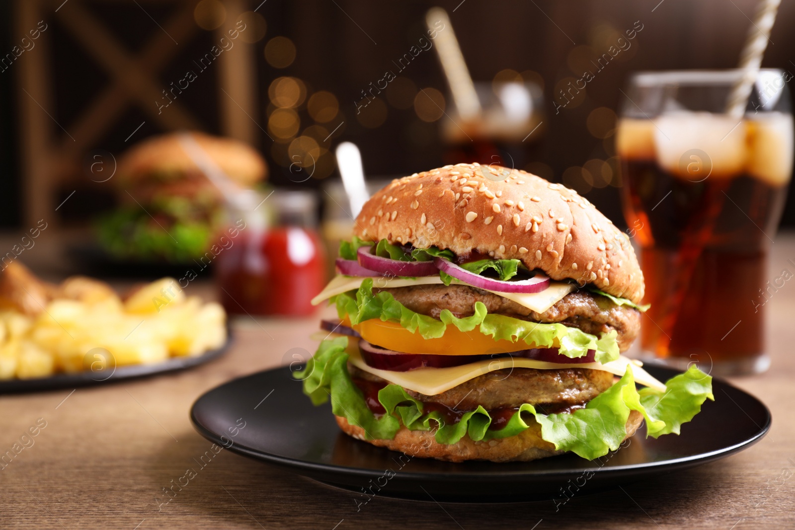 Photo of Plate with delicious hamburger on wooden table. Space for text