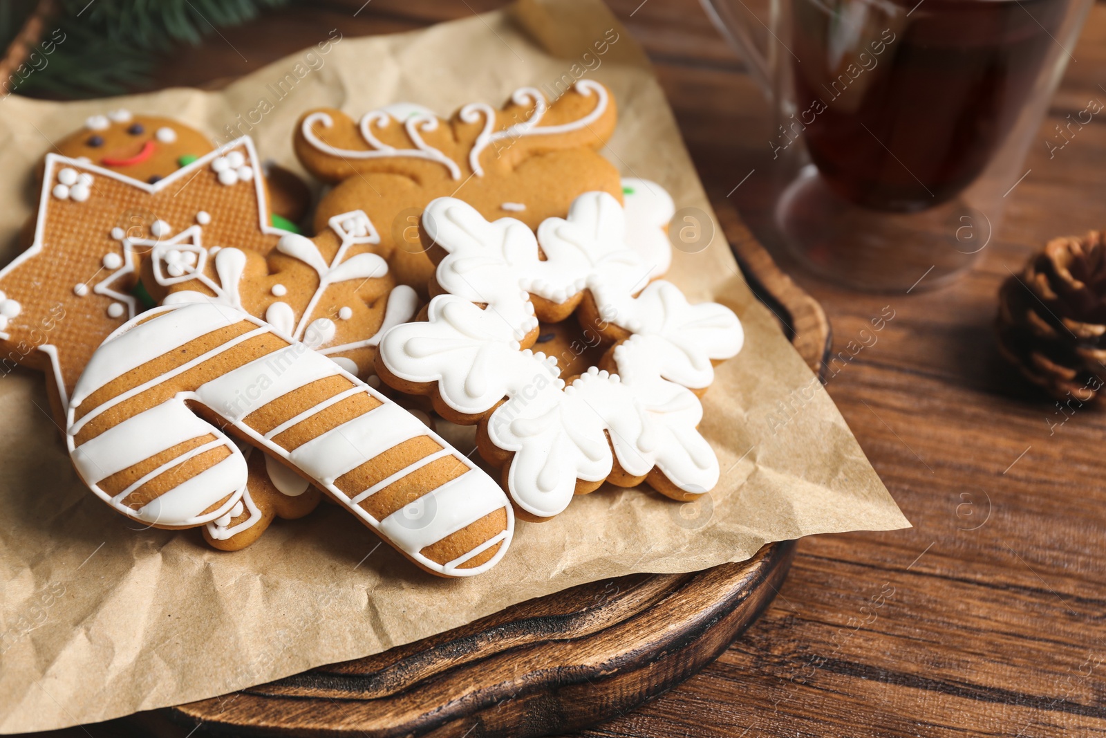 Photo of Board with tasty Christmas cookies on wooden table, closeup