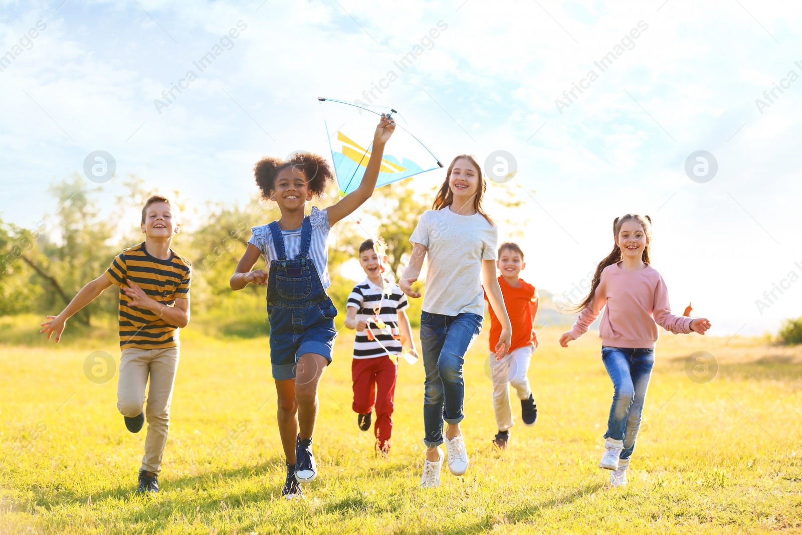 Photo of Cute little children playing with kite outdoors on sunny day