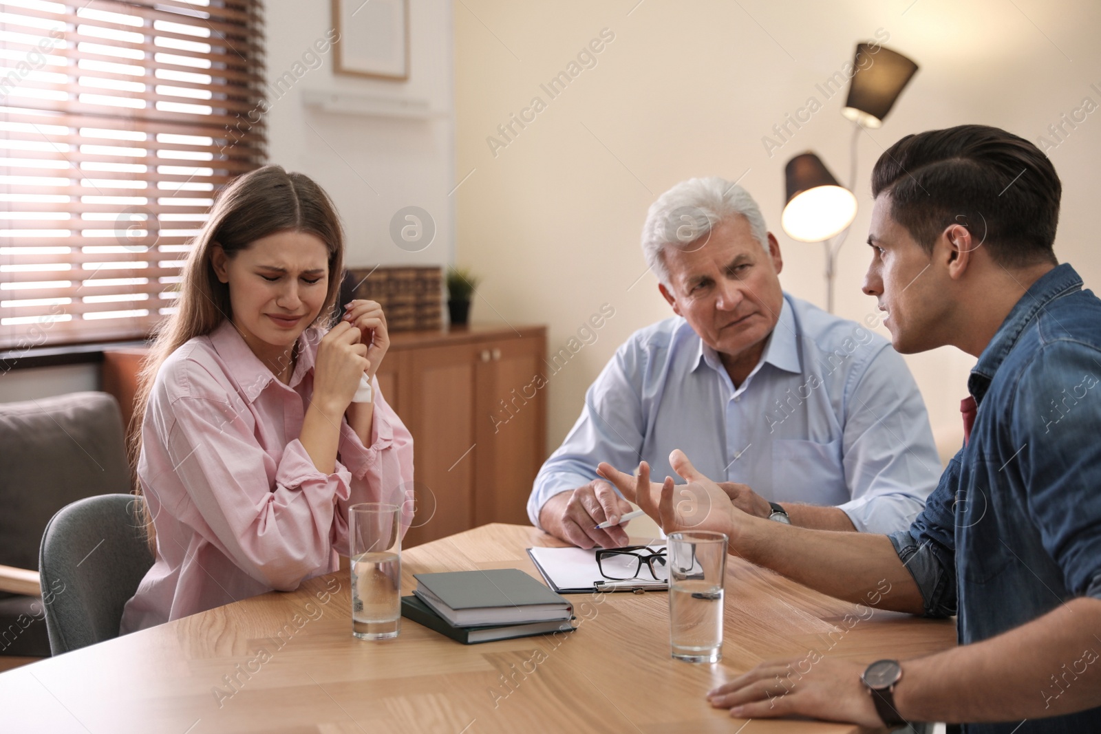 Photo of Professional psychotherapist working with emotional couple in office