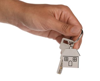 Photo of Woman holding key with metallic keychain in shape of house on white background, closeup